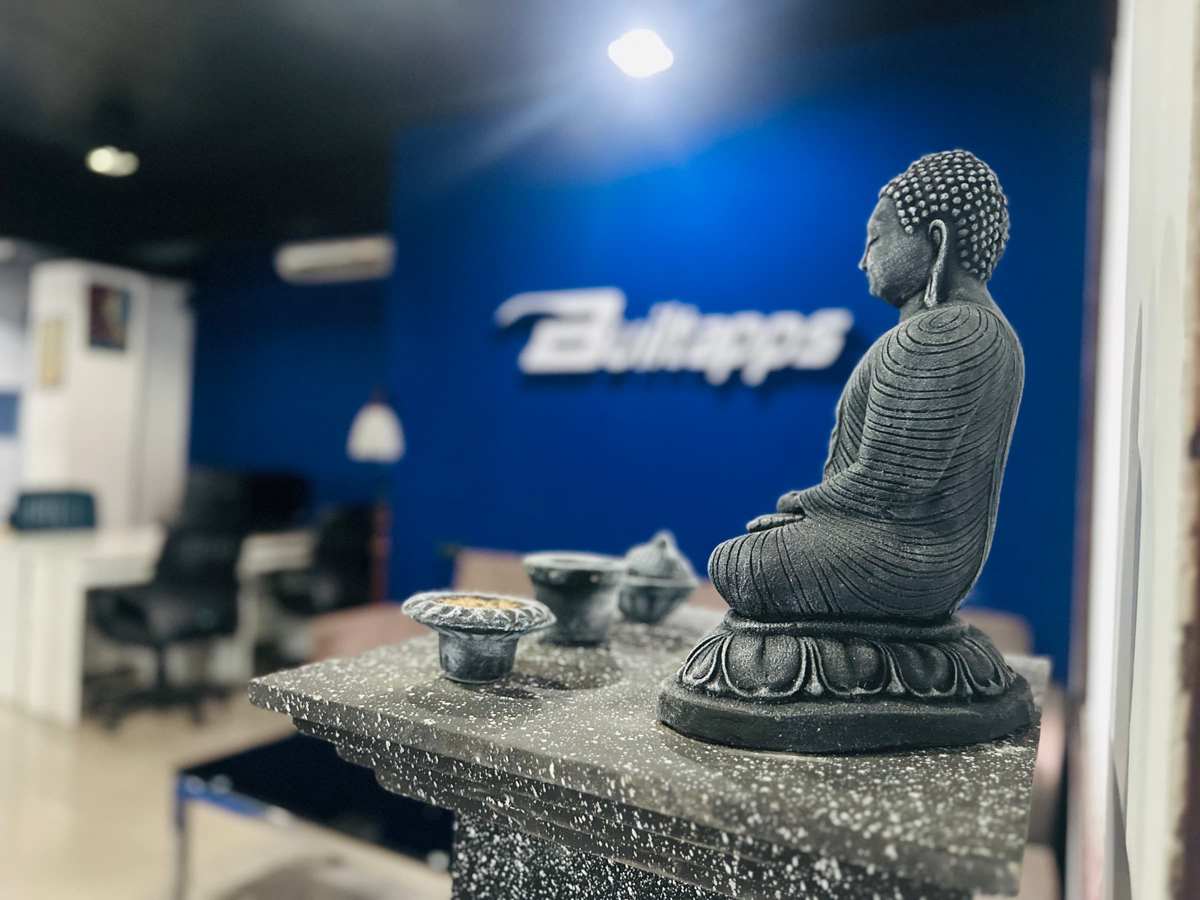 Office decor with Buddha statue and Builtapps logo