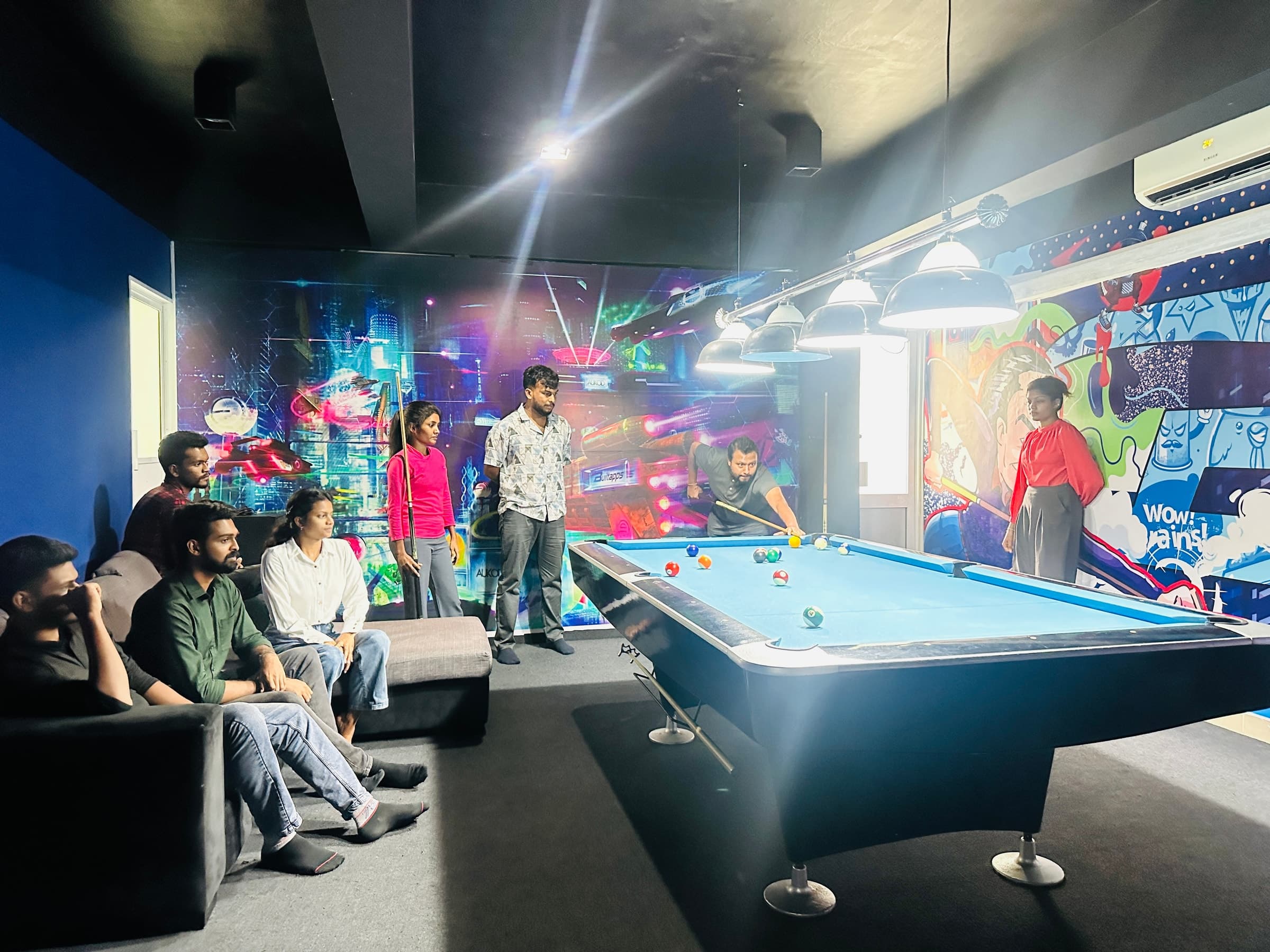 Team gathered around the office pool table