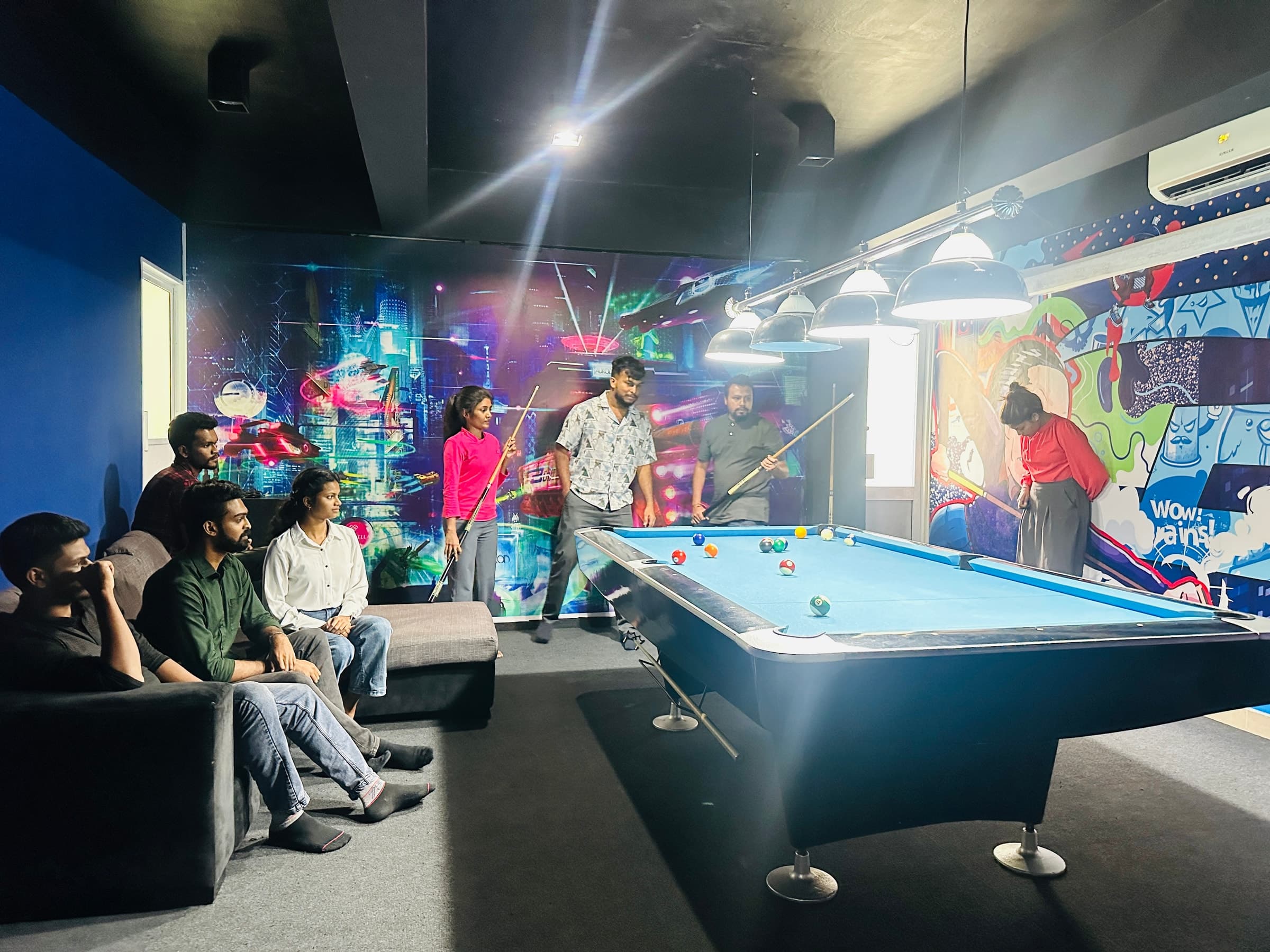 Team watching a pool game in the recreation room